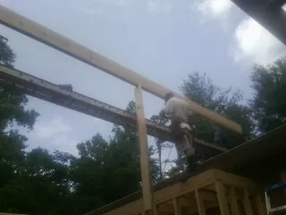 Carpenter setting a ridge beam over a new addition frame — Ice Dam Removal by Roofing Brothers in Cle Elum