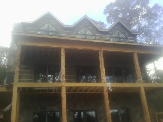 Dormers and porch framing on a large log home under construction — Roof Coating work by our crew in Cle Elum